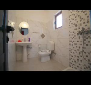 a bathroom with a toilet and a sink and a shower at Koci Apartments in Sarandë +27 photos