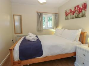 a bedroom with a bed with white sheets and a window at 15 The Dell in Norwich
