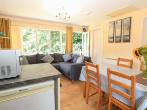 a kitchen and living room with a couch and a table at 15 The Dell in Norwich