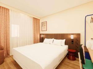 a bedroom with a large white bed in a room at ibis Styles Lyon Gerland in Lyon