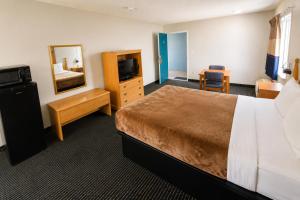 a hotel room with a bed and a mirror at Relax Inn Dover Near Speedway in Dover +16 photos