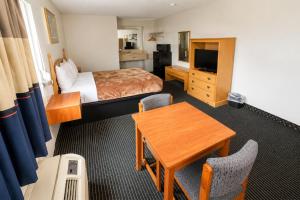 a hotel room with a bed and a table at Relax Inn Dover Near Speedway in Dover