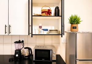 a kitchen counter with a microwave and a refrigerator at Toby's Apartment in Mbabane