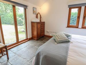 a bedroom with a bed and large windows at Owl Cottage in Woodbridge