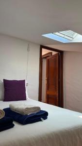 a bed with towels on it with a ceiling at A Casa do Peregrino in A Guarda