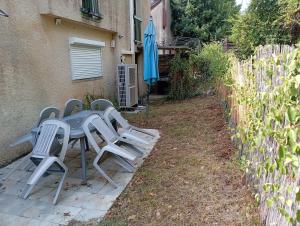 a table and chairs with an umbrella and a fence at Maison de vacances Pradines in Pradines