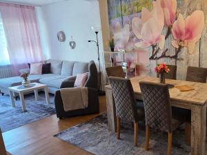 a living room with a table and a couch at Ferienwohnung FeLuMi in Wadgassen