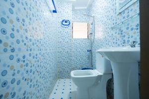 a bathroom with a white toilet and a sink at Residence Singa in Abidjan +46 photos