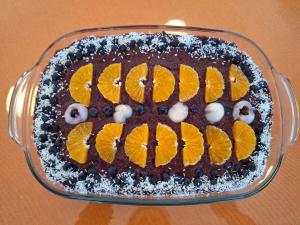 a chocolate cake with orange slices on top in a glass dish at Centrul 3H in Sub Piatra