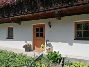 a house with a wooden door and flowers at Ferienwohnung Mittergutnigg in Innervillgraten
