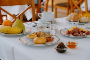 a white table with plates of food on it at Hotel Aguiar da Pena in Vila Pouca de Aguiar