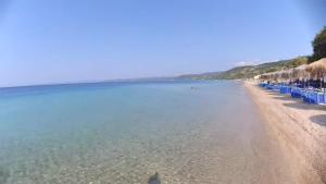 a beach with blue beach chairs and the water at Casa Patronimio Aristotle Socrates Residence in Ierissos