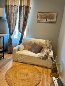 a white couch in a living room with a window at Refuge champêtre in Champagnole