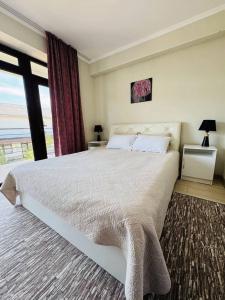 a bedroom with a large bed and a large window at Baytur Resort таунхаус in Bosteri +38 photos
