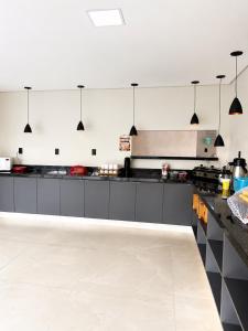 a kitchen with black and white cabinets and appliances at Vila inn hotel in Brasília