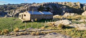 a small stone building with a mountain in the background at Rinconcito Serrano in Mina Clavero