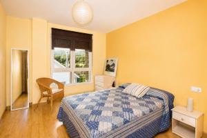 a bedroom with a bed and a window at Apartamento Mar de Carnota in San Mamede de Carnota