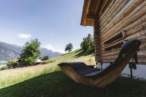 a wooden boat sitting on the grass next to a house at Maiensäss, Berghütte Chlara - autark, voll ausgestattet, Ressourcen begrenzt in Untervaz