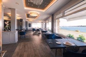 a restaurant with tables and chairs and a view of the ocean at Hostellerie De La Mer in Crozon