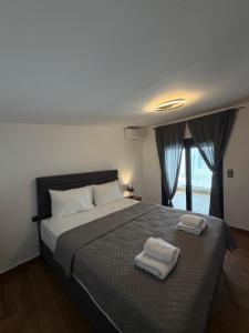 a bedroom with a large bed with two towels on it at Diktamo Village House in Ofrínion