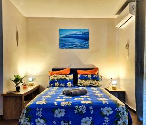 a bedroom with a bed with a blue comforter at Teahupo'o Lodge Tahiti - Studio Moana, lagon et quai en face - Canoës inclus in Teahupoo