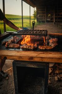 a grill with some meat on top of it at Lumea lui Creanga in Topoliţa