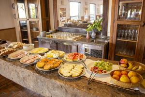 a buffet with many plates of food on a table at Pousada Engenho da Lagoa in Garopaba