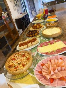 a table with many different types of pies and pizzas at Pousada Engenho da Lagoa in Garopaba +7 photos