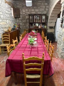 a long table with a purple table cloth and chairs at Cal Rabell in Bellmunt