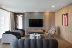 a living room with a couch and a tv at Hôtel Le Germain Montréal in Montreal
