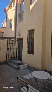 two chairs and tables in front of a building at Cozy Townhouse in Yerevan