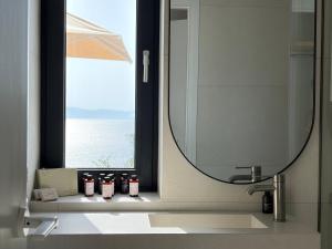 a bathroom with a mirror and a sink and a window at KITO suites in Kitriaí +69 photos