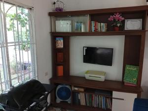 a living room with a tv and a book shelf at Paz y Libertad in San Pedro Mártir
