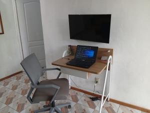 a laptop computer sitting on a desk with a chair at Paz y Libertad in San Pedro Mártir