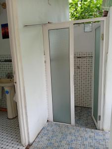a glass shower door in a bathroom with a tiled floor at Paz y Libertad in San Pedro Mártir