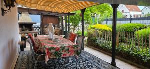 a table and chairs on a patio with an umbrella at Ferienwohnung FeLuMi in Wadgassen