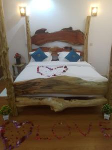 a bedroom with a wooden bed with flowers on the floor at Goldenview Gardens Elementaita in Gilgil