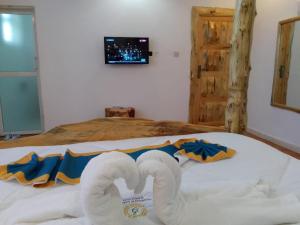 a bedroom with two towels on a bed at Goldenview Gardens Elementaita in Gilgil