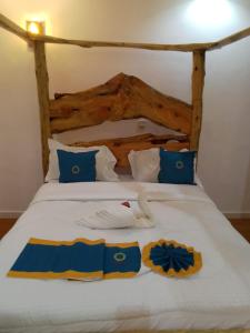 a bedroom with a bed with blue and white pillows at Goldenview Gardens Elementaita in Gilgil