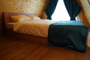 a bedroom with a large bed with a window at Andrei's Refugium in Ocnele Mari