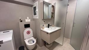a small bathroom with a toilet and a sink at Sigma Exotic Palio Beach Apartment in Paleo Tsifliki