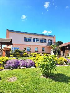 a building with flowers in front of a yard at Ferienwohnung Familie Windt in Feldberg