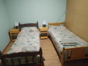 two twin beds in a room with two lamps at Los abuelos 28 in Estación La Dorotea