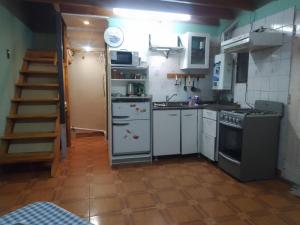 a small kitchen with white appliances and a staircase at Los abuelos 28 in Estación La Dorotea