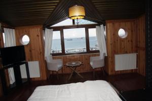 a bedroom with a bed and a window and a television at Denizci Hotel in Sinop