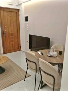 a dining room with a wooden table and chairs at Garden apartment G in Xanthi