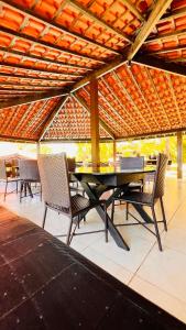 a table and chairs on a patio with a roof at HOTEL IBIZA CUMBUCO in Cumbuco