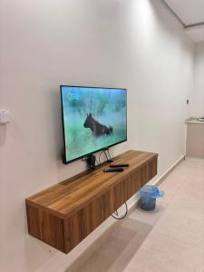 a flat screen tv sitting on top of a wooden entertainment center at ايراد للشقق المفروشه in Dammam
