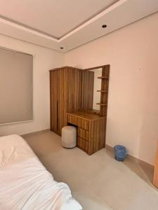 a bedroom with a bed and a wooden desk at ايراد للشقق المفروشه in Dammam