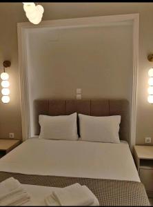 a bedroom with a bed with white sheets and pillows at Garden apartment G in Xanthi